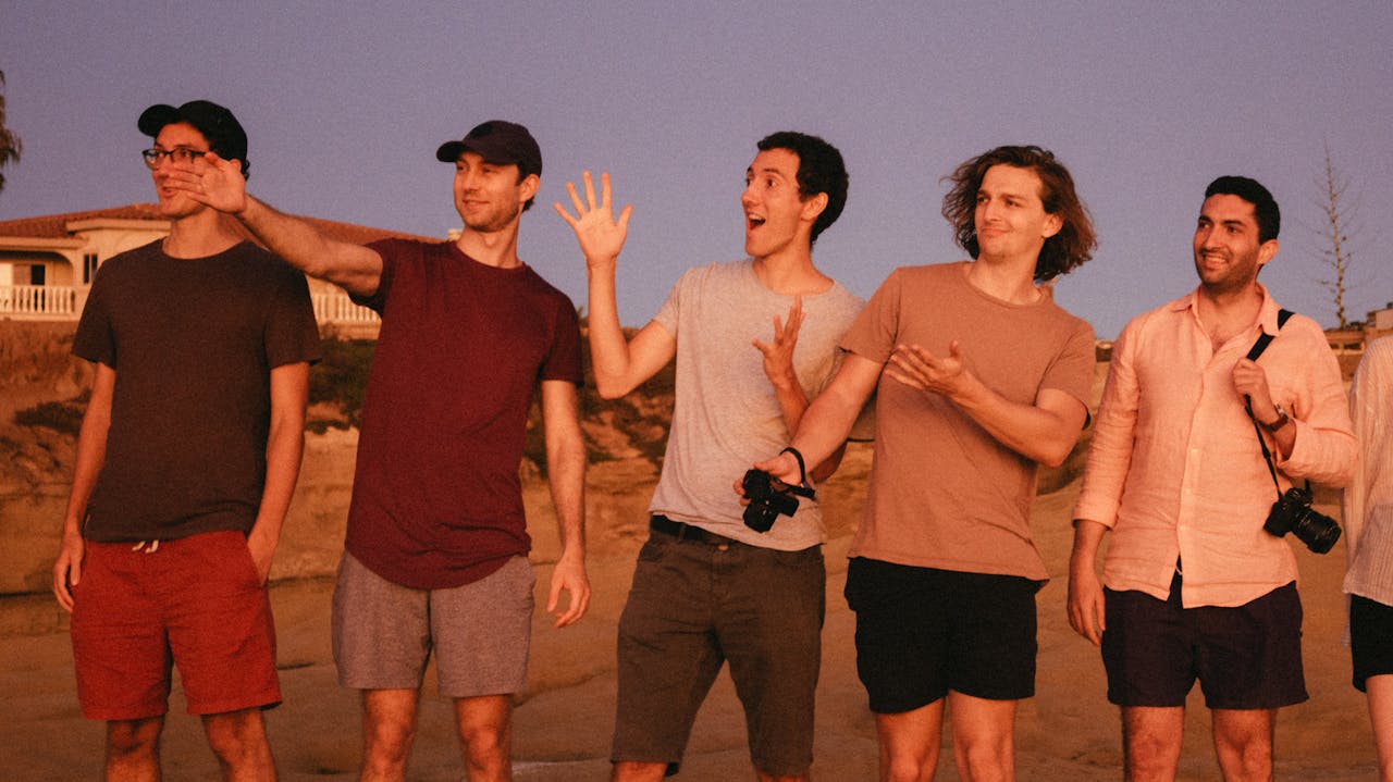 A group of young men enjoying a casual photo session outdoors during sunset.